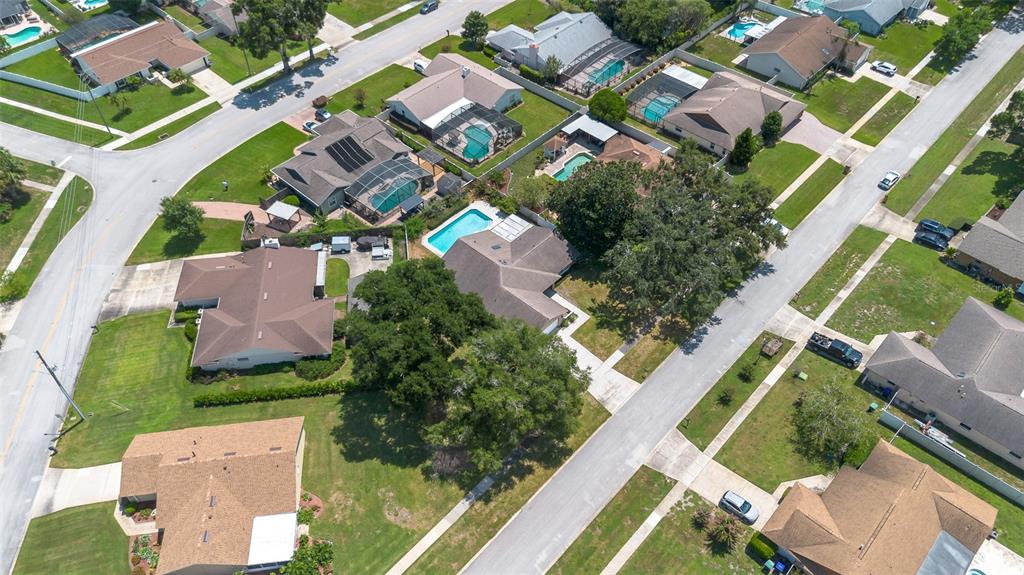 An aerial view shows several suburban houses with swimming pools and trees on a residential street — 8971 ANGELICA DRIVE, ORLANDO, FL