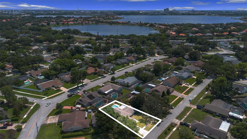 An aerial view shows a single-story house with a pool and yard in a neighborhood — 8971 ANGELICA DRIVE, ORLANDO, FL