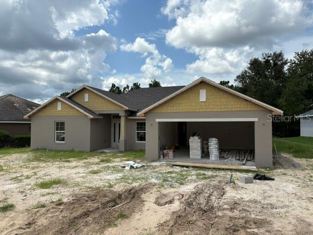 A newly constructed single-story house with a two-car garage and tan stucco exterior — 6734 SW 179TH AVENUE ROAD, DUNNELLON, FL
