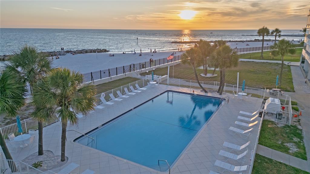 An open, unfinished concrete garage with exposed block walls and a metal overhead door — 7000 BEACH PLAZA UNIT 202, ST PETE BEACH, FL