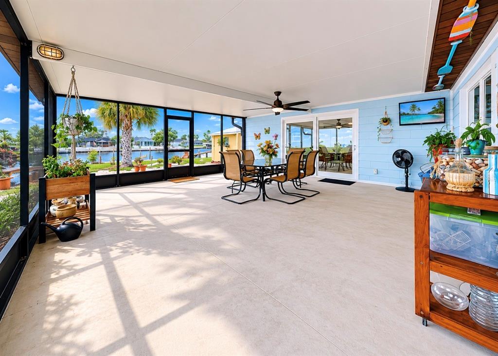 A screened-in patio features a dining set, light blue siding, and views of a canal — 803 LEISEY CIRCLE, RUSKIN, FL