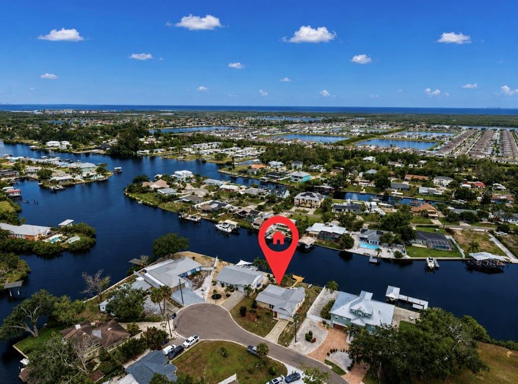 An aerial view shows a waterfront house with a red location pin in Florida — 803 LEISEY CIRCLE, RUSKIN, FL