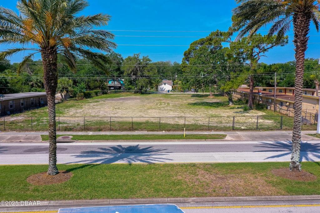 An aerial view shows a vacant, fenced-in lot situated between two residential buildings — 670 S YONGE STREET, ORMOND BEACH, FL
