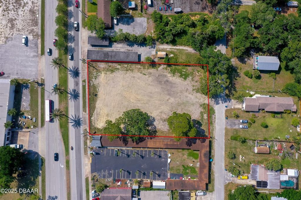 An aerial view shows a vacant rectangular lot outlined in red next to a road — 670 S YONGE STREET, ORMOND BEACH, FL
