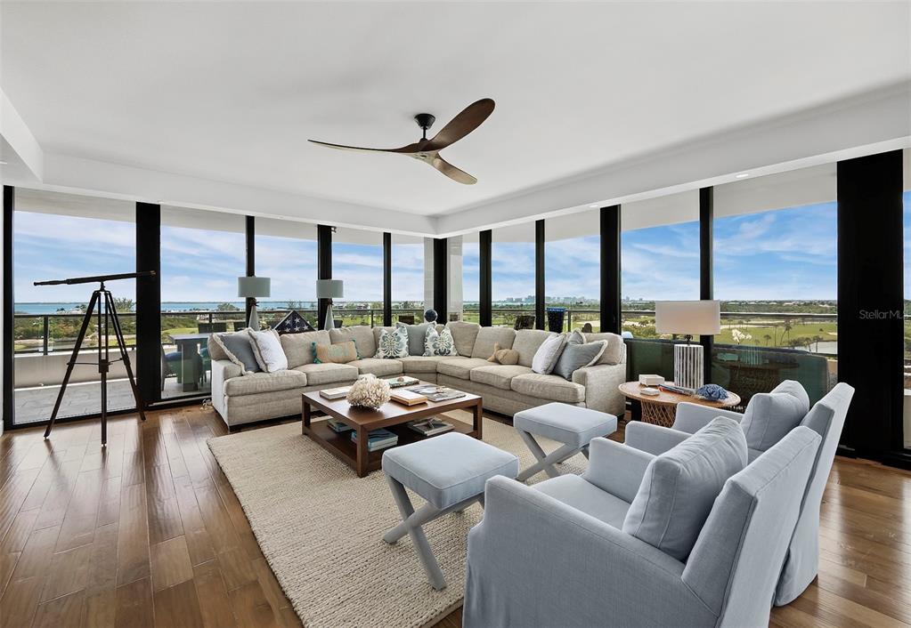 A living room features a large sectional sofa, two armchairs, and floor-to-ceiling windows with views — 535 SANCTUARY DRIVE UNIT A603, LONGBOAT KEY, FL