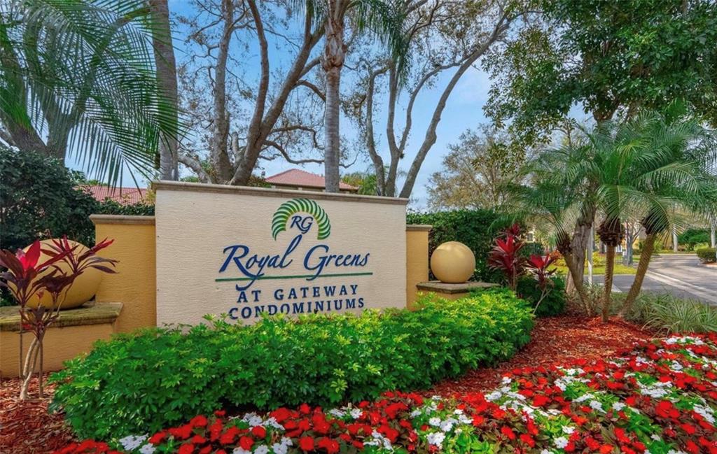 A beige monument sign for Royal Greens at Gateway Condominiums surrounded by landscaping and flowers — 11490 VILLA GRAND UNIT 221, FORT MYERS, FL
