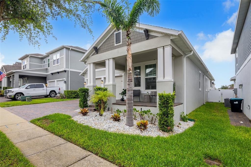 A single-story house with a covered front porch, palm tree, and paved driveway — 15009 LEBEAU LOOP, WINTER GARDEN, FL