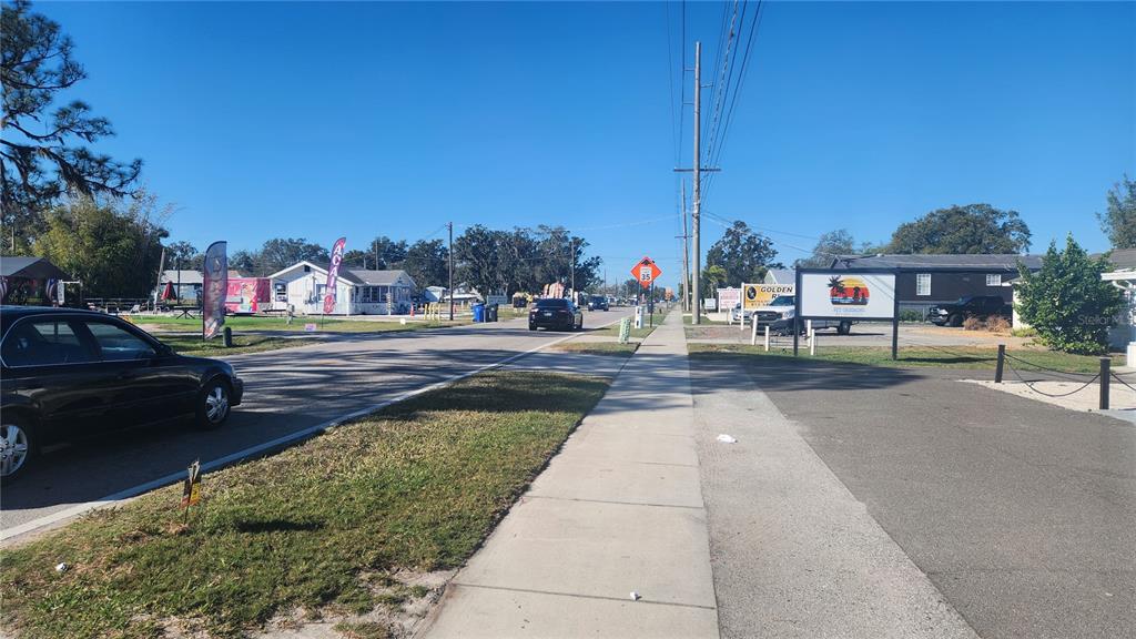 A view of a paved street with a sidewalk, utility poles, and surrounding commercial buildings — 201 W SHELL POINT ROAD, RUSKIN, FL