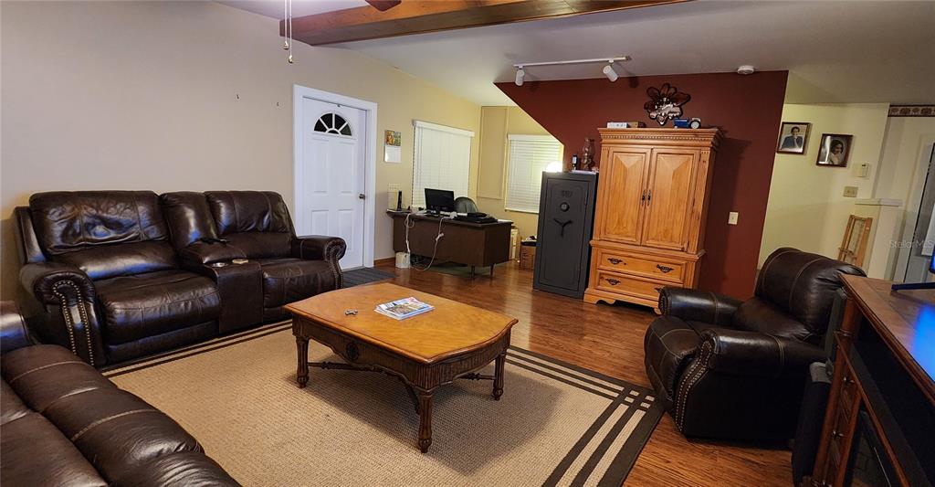 A living room features leather furniture, a wooden coffee table, and a desk area — 1190 S GOODMAN ROAD, CHAMPIONS GATE, FL