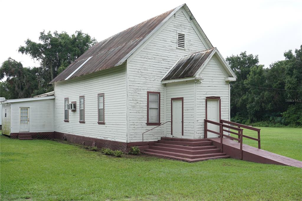 A white wooden church building with a metal roof, stairs, and a wheelchair ramp — 12701 NW 38TH AVENUE, REDDICK, FL