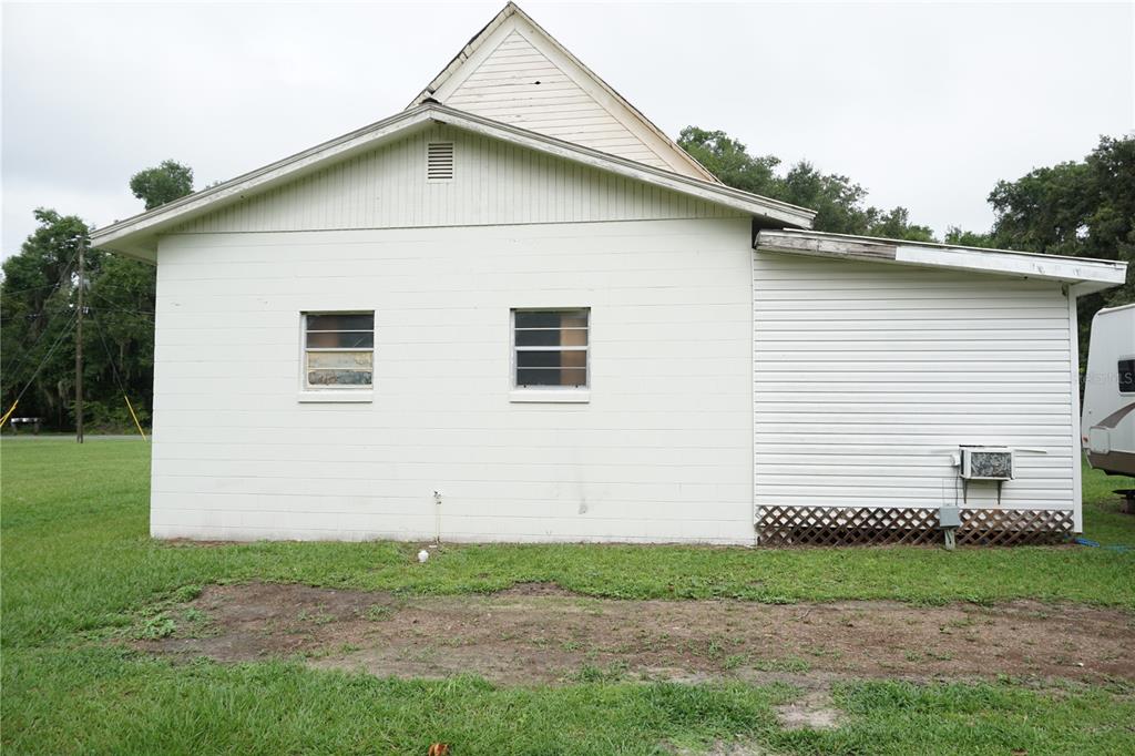 The exterior of a white, single-story house with a gabled roof and two windows — 12701 NW 38TH AVENUE, REDDICK, FL