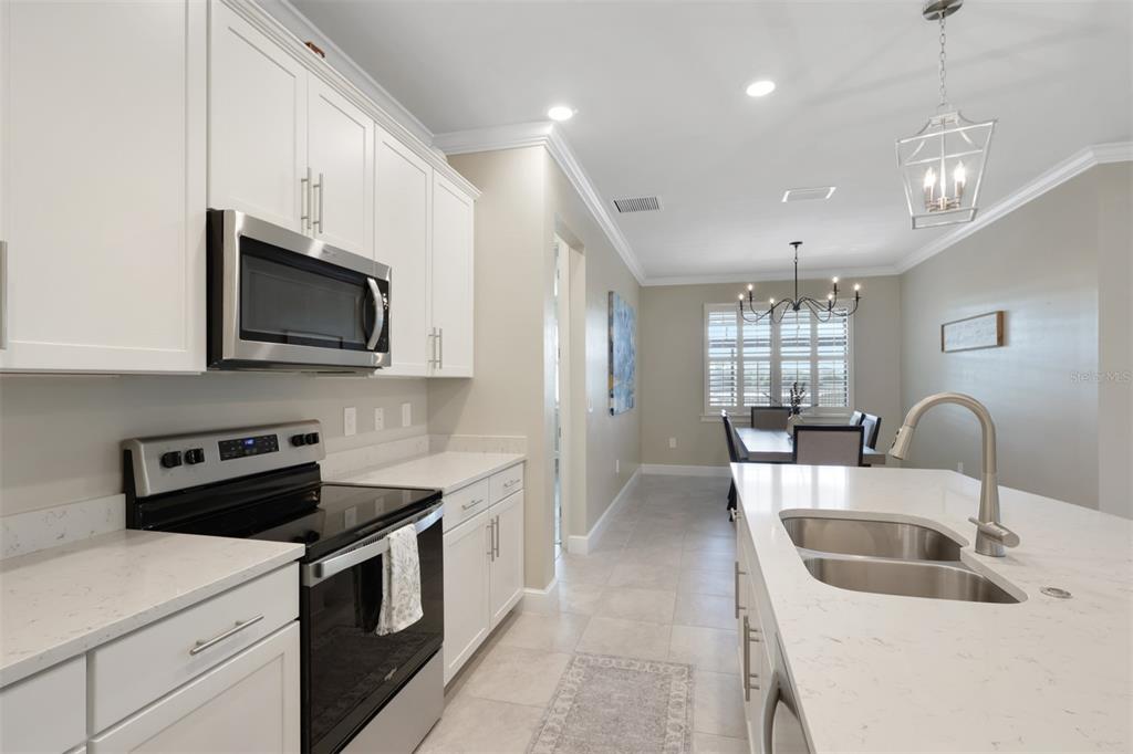 A kitchen with white cabinets, stainless steel appliances, and a quartz-topped island — 3425 HAMPTON BOULEVARD, ALVA, FL