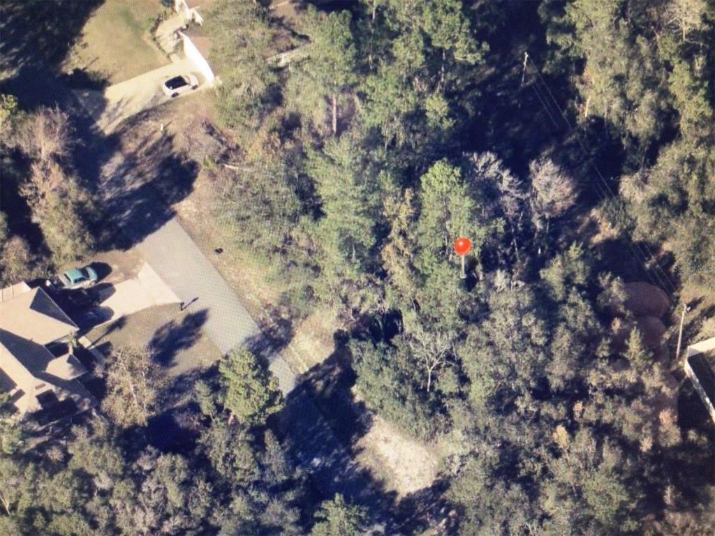 An aerial view shows a wooded residential lot with a red location marker — 0 SW 25 CIRCLE, OCALA, FL
