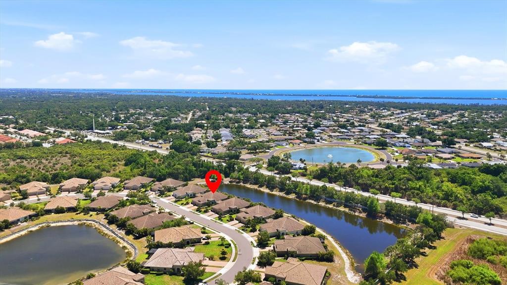 An aerial view shows a suburban neighborhood with houses surrounding ponds and a red pin — 1359 BACKSPIN DRIVE, ENGLEWOOD, FL