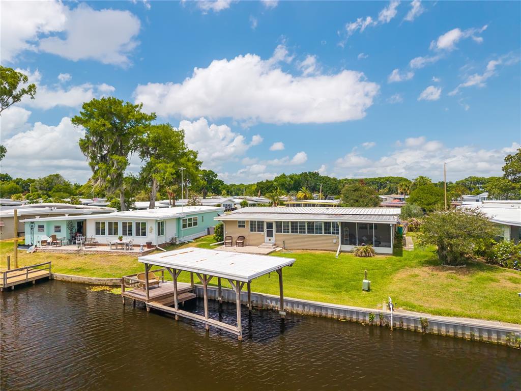 A single-story manufactured home with a concrete driveway and a white mailbox in the yard — 957 TODD WAY, TAVARES, FL