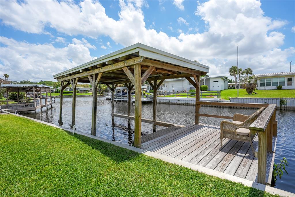A single-story house with tan siding, a carport, and a paved walkway in the front — 957 TODD WAY, TAVARES, FL