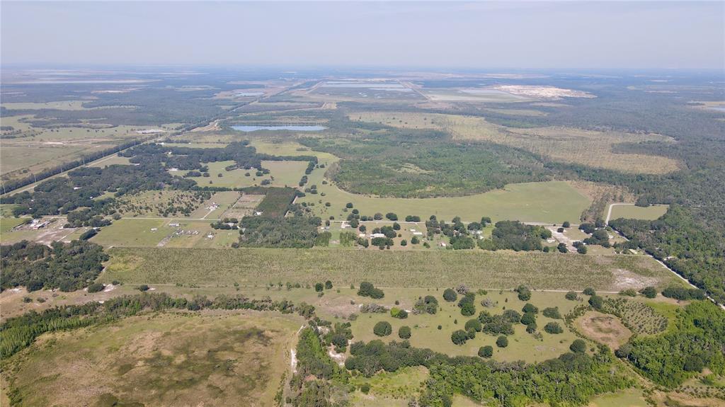 An aerial view shows a large rural landscape with scattered houses, pastures, and wooded areas — ALBRITTON, LITHIA, FL