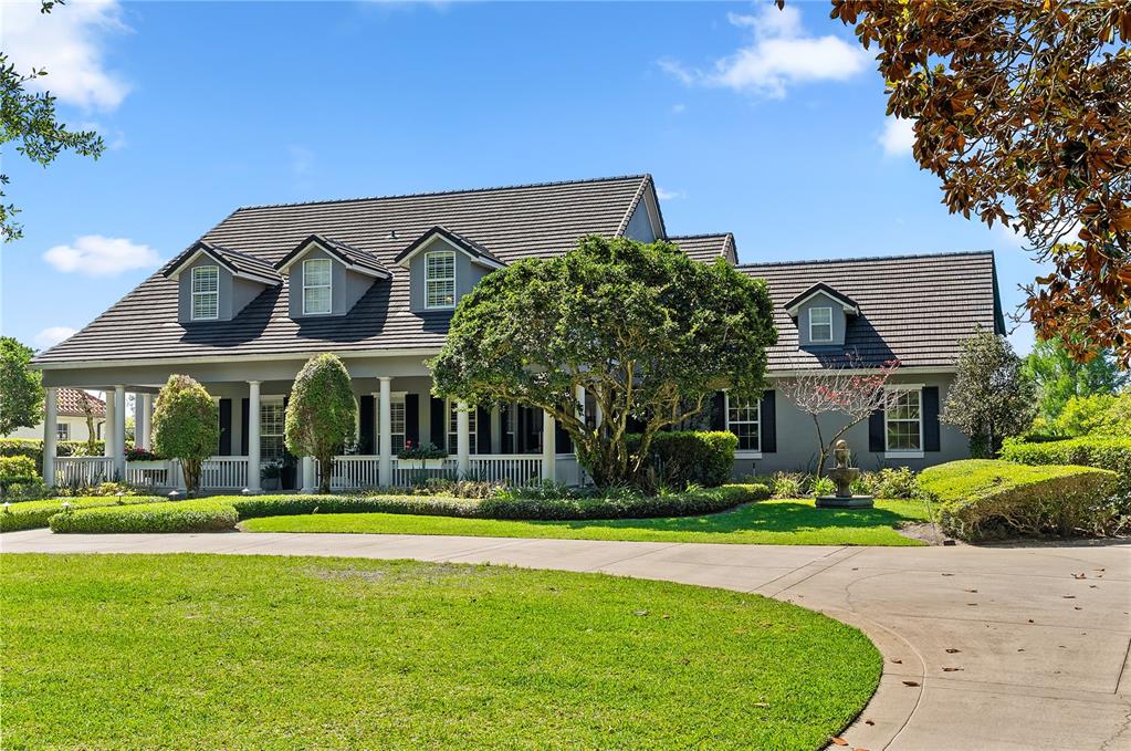An aerial view shows a house with a dock extending into a lake — 9648 WEATHERSTONE COURT, WINDERMERE, FL