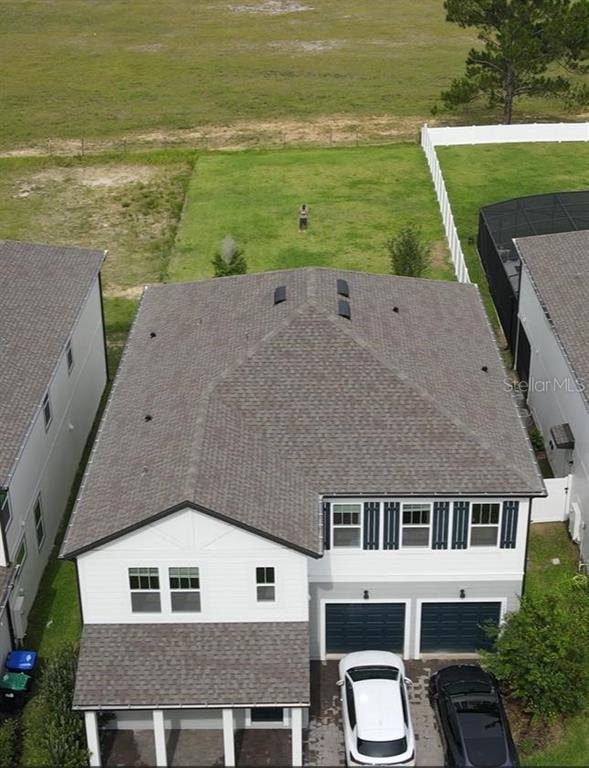 An aerial view shows a two-story house with a shingled roof and a backyard — 17242 LAKE STAR ROAD, WINTER GARDEN, FL