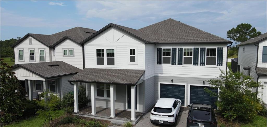 An exterior view of a two-story house with a white and gray facade and garage — 17242 LAKE STAR ROAD, WINTER GARDEN, FL