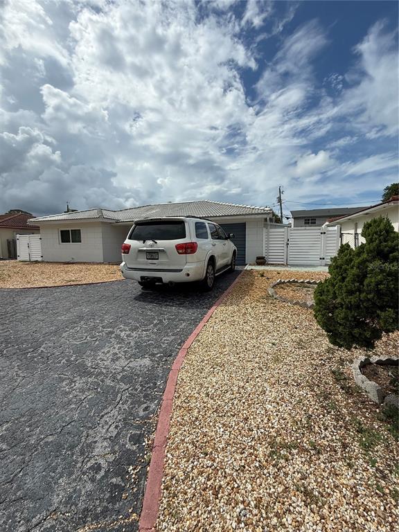 A white SUV is parked on a dark driveway in front of a single-story house — 52 45TH AVENUE, ST PETE BEACH, FL