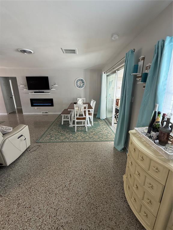 A dining area with a table and chairs sits on a rug near a fireplace — 52 45TH AVENUE, ST PETE BEACH, FL