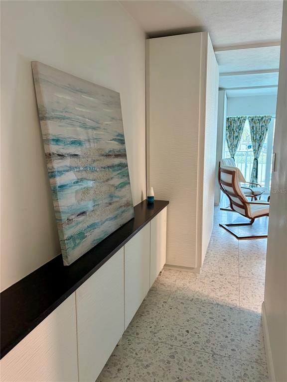 A living room features a grey sectional sofa, a wooden coffee table, and patterned curtains — 3700 S ATLANTIC AVENUE UNIT 207, NEW SMYRNA BEACH, FL