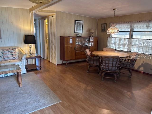 A dining area with a wooden table and chairs sits adjacent to a living room space — 714 S GREEN CIRCLE, VENICE, FL
