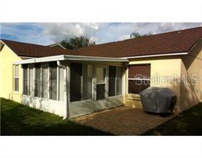 The exterior of a house features a screened-in porch, a brick patio, and a grill — 13109 ELGAR PLACE, RIVERVIEW, FL