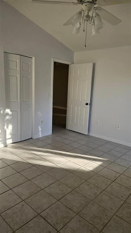 A room with light-colored tile flooring, a ceiling fan, and two white interior doors — 13109 ELGAR PLACE, RIVERVIEW, FL