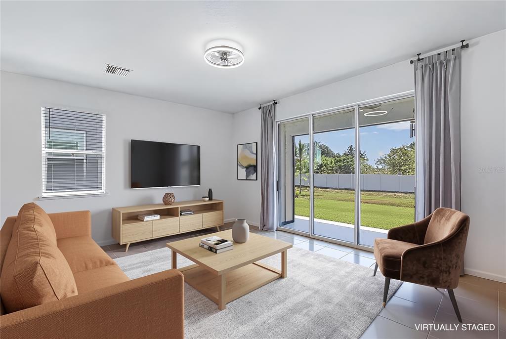 A living room features tile flooring, a red sectional sofa, and a sliding glass door — 388 MANGROVE SHADE CIRCLE, APOLLO BEACH, FL