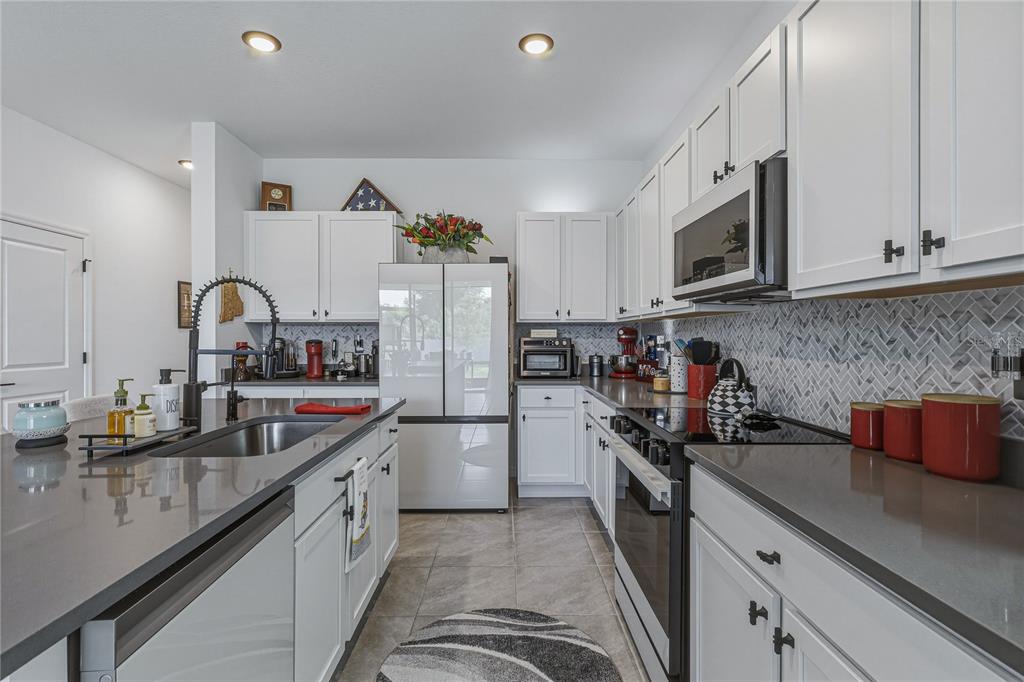 A room with a desk, a gray loveseat, a tufted ottoman, and a dark wood cabinet — 388 MANGROVE SHADE CIRCLE, APOLLO BEACH, FL