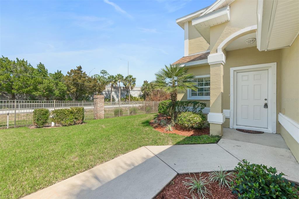A view of a house exterior featuring a white front door, walkway, and lawn — 2001 PALM DRIVE UNIT B101, FLAGLER BEACH, FL