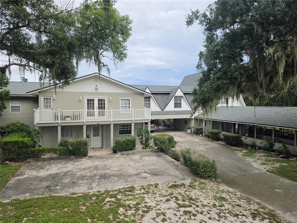 A two-story house with a balcony, a covered driveway, and a long screened-in porch — 201 LAKE BONNY DRIVE E, LAKELAND, FL