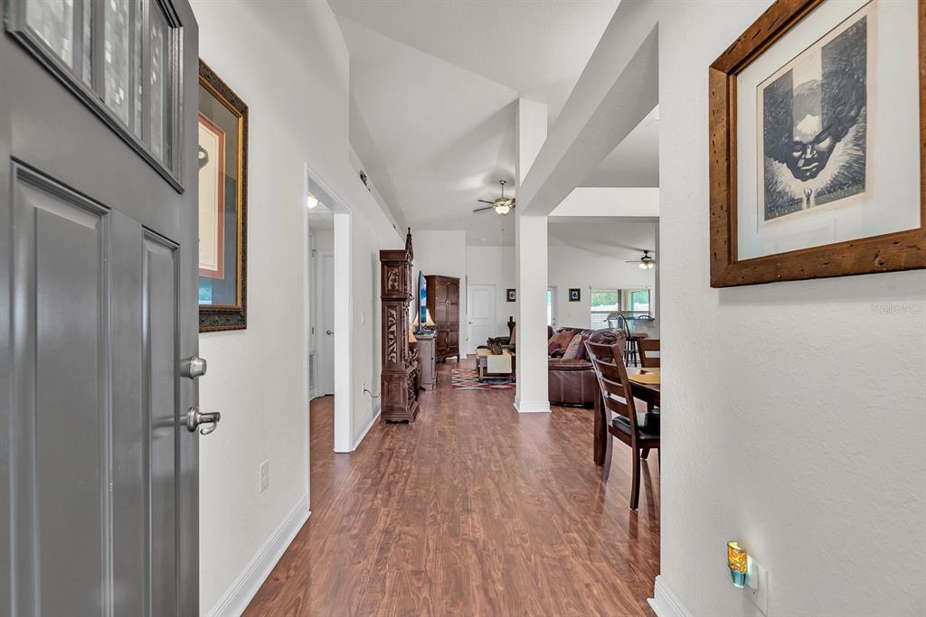 A view from an entryway looking into a living room with wood-look flooring and vaulted ceilings — 12250 LEGACY BRIGHT STREET, RIVERVIEW, FL