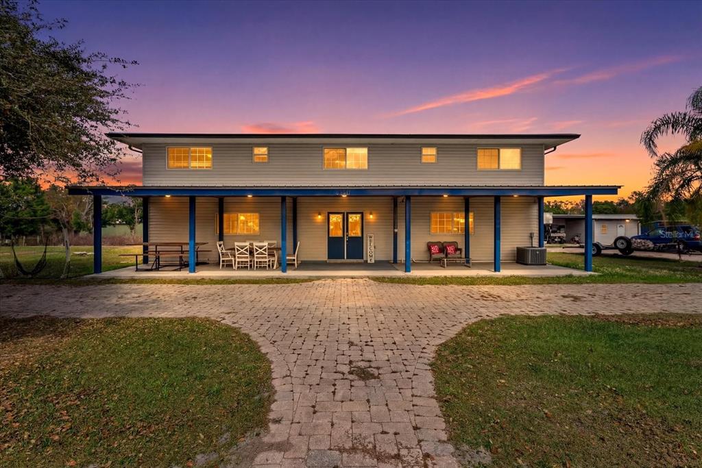 A bedroom features a bed, tile flooring, a drop ceiling, and a blue door — 8360 SW EASY STREET, ARCADIA, FL