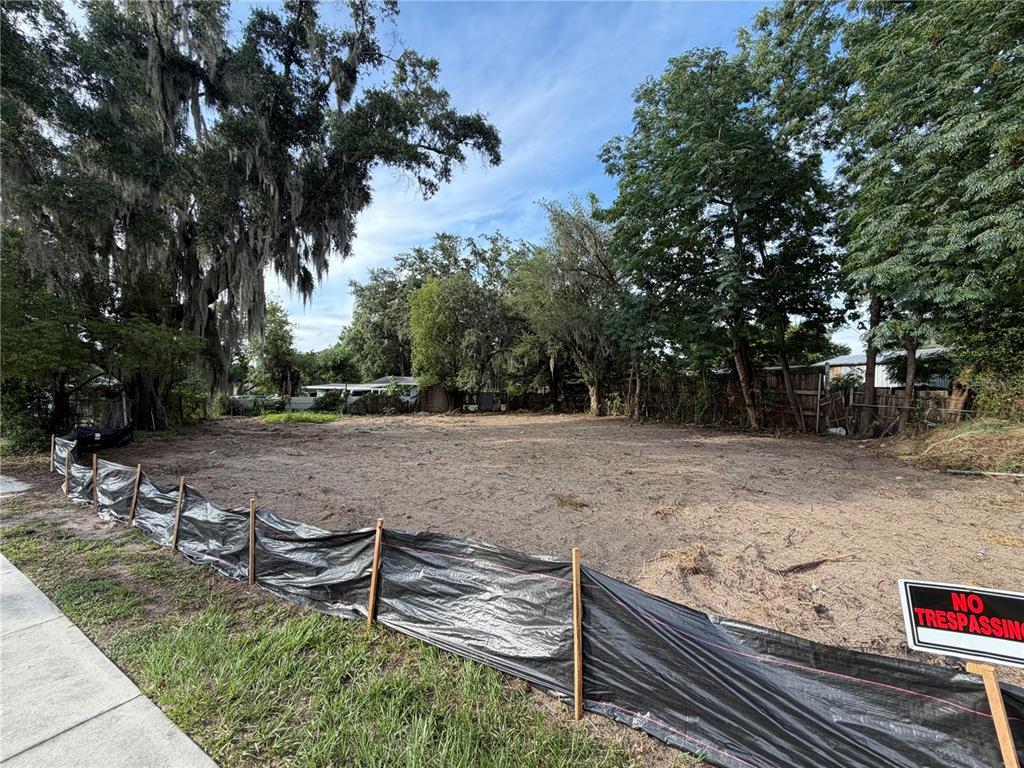 A vacant, cleared residential lot is enclosed by a black silt fence and trees — 1185 APOPKA BOULEVARD, APOPKA, FL