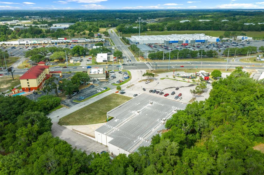 An aerial view shows a commercial building with a large parking lot near a highway — 2500 CITRUS BOULEVARD, LEESBURG, FL