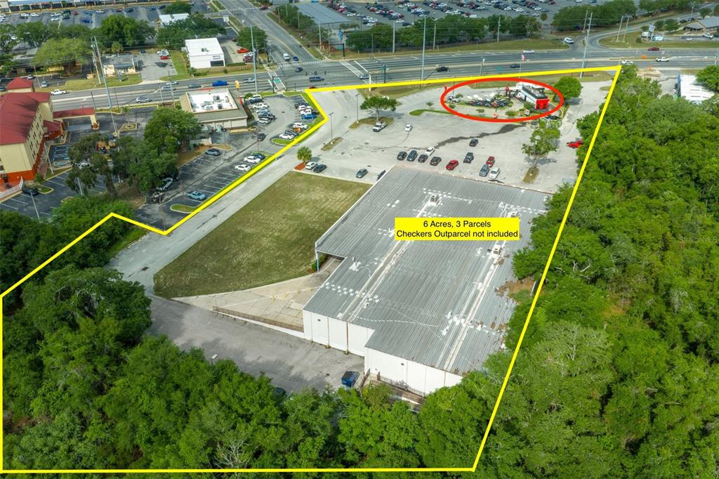 An aerial view shows a commercial building and parking lot outlined in yellow with an outparcel — 2500 CITRUS BOULEVARD, LEESBURG, FL