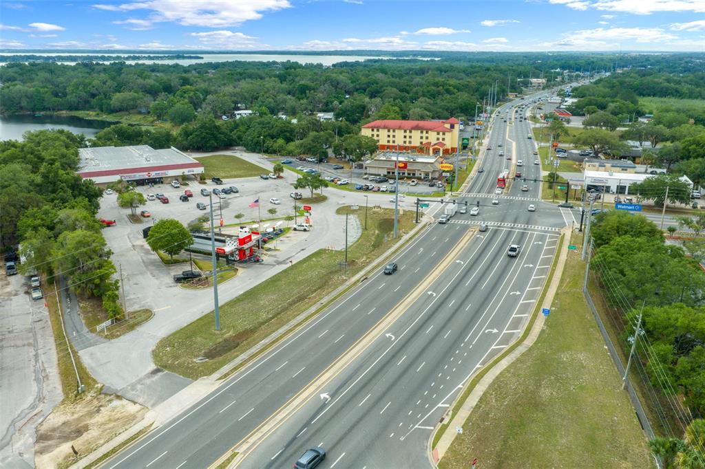 An aerial view shows a multi-lane highway intersection adjacent to a commercial parking lot — 2500 CITRUS BOULEVARD, LEESBURG, FL