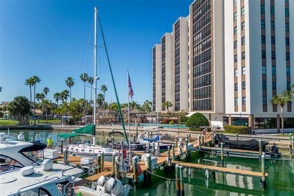 A high-angle view shows several boats docked at a wooden pier on a sunny day — 10355 PARADISE BOULEVARD UNIT 213, TREASURE ISLAND, FL