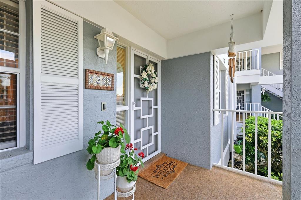 A sunroom features a dining set, a ceiling fan, and large windows overlooking a marsh — 1323 PERICO POINT CIRCLE UNIT 107, BRADENTON, FL