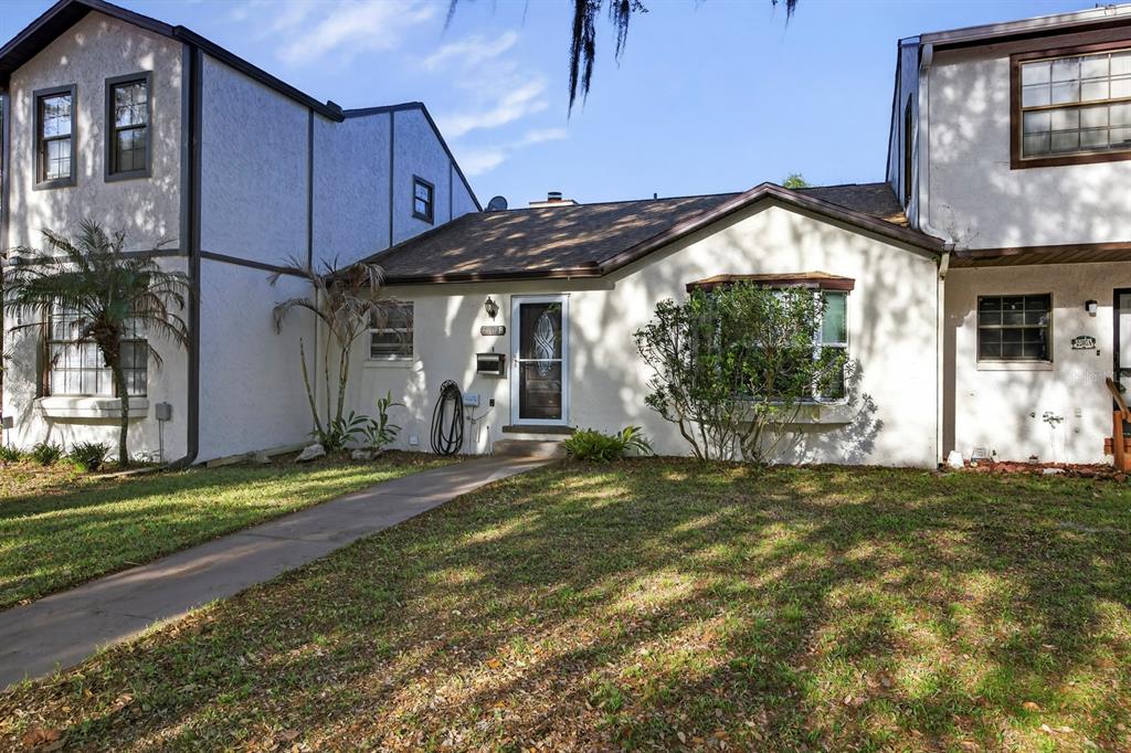 A single-story house with a white stucco exterior and a brown shingled roof — 2207 KARL STREET UNIT B, LEESBURG, FL