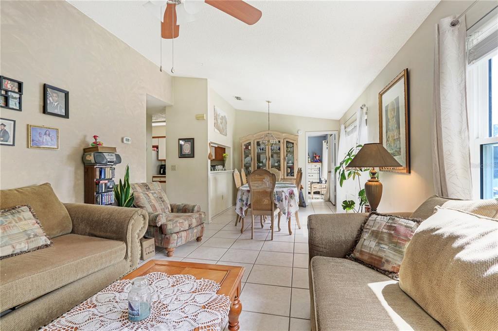 A living room with beige sofas and a dining area with a hutch and table — 2005 NORTHLAKE DRIVE, SANFORD, FL