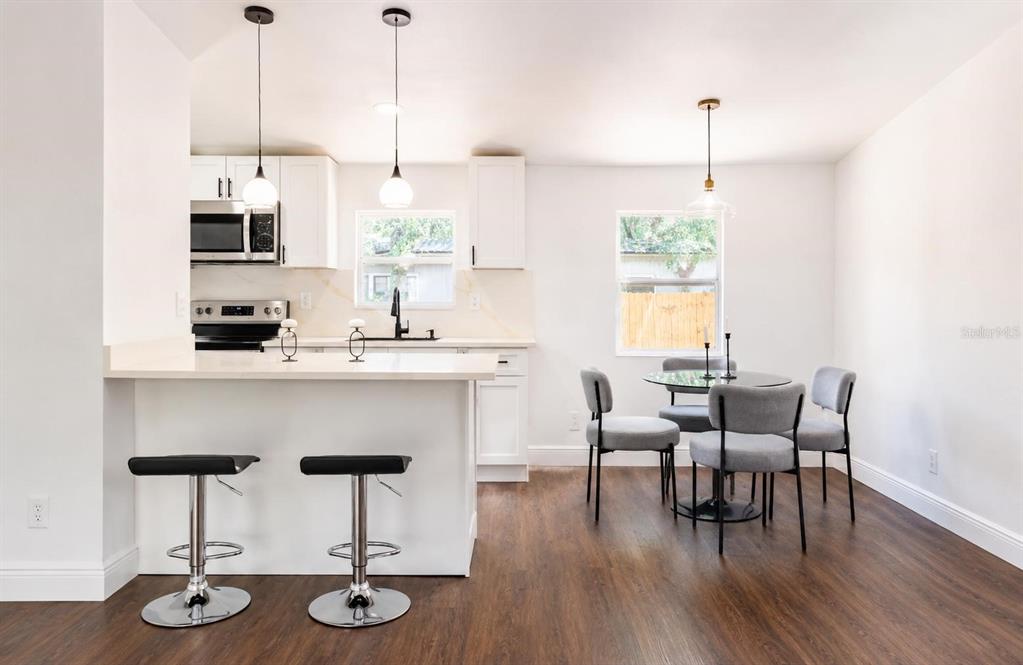 A modern living room features a fireplace, dark wood floors, and an open-concept kitchen — 1809 NE 162ND STREET, CITRA, FL