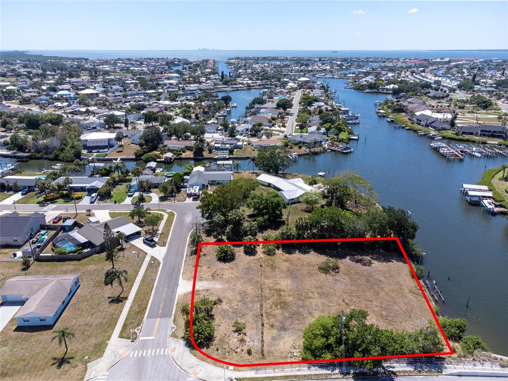 An aerial view shows a vacant, rectangular waterfront lot outlined in red — 601 FLAMINGO DRIVE, APOLLO BEACH, FL