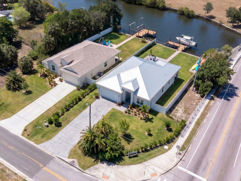 An aerial view shows two waterfront houses with boat docks along a canal — 601 FLAMINGO DRIVE, APOLLO BEACH, FL