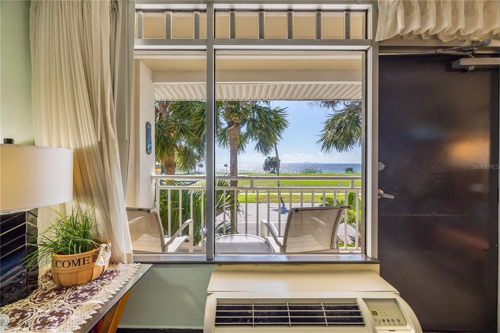 A view of a balcony and the ocean through a window in a room — 611 DESTINY DRIVE UNIT 204, RUSKIN, FL