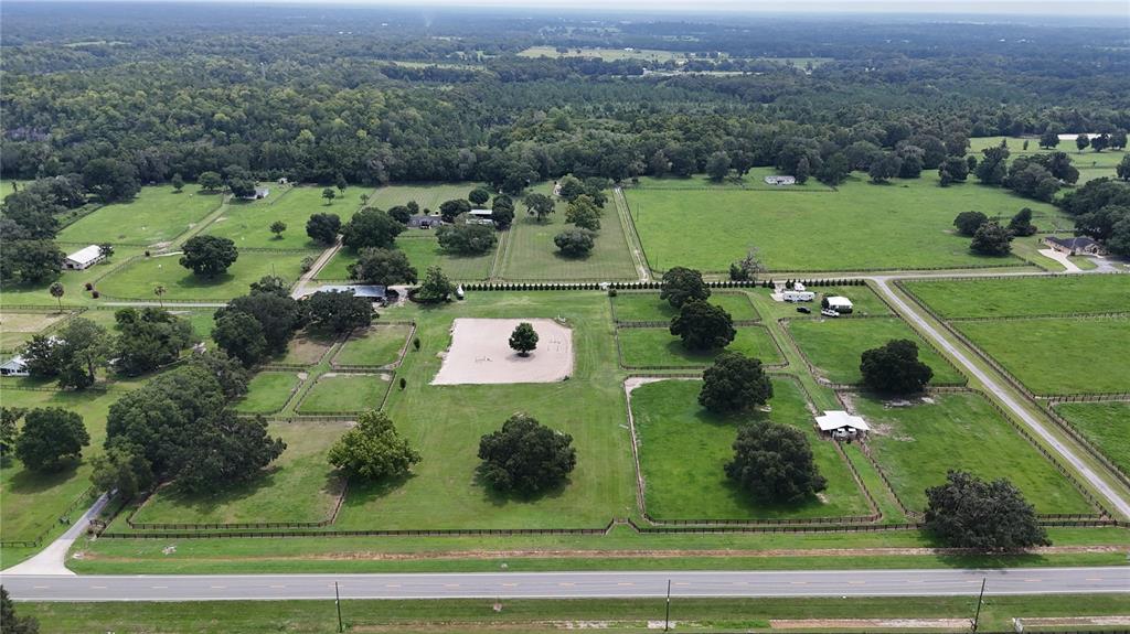 An aerial view shows a large rural property with fenced pastures, scattered trees, and buildings — 13489 NW GAINESVILLE ROAD, REDDICK, FL