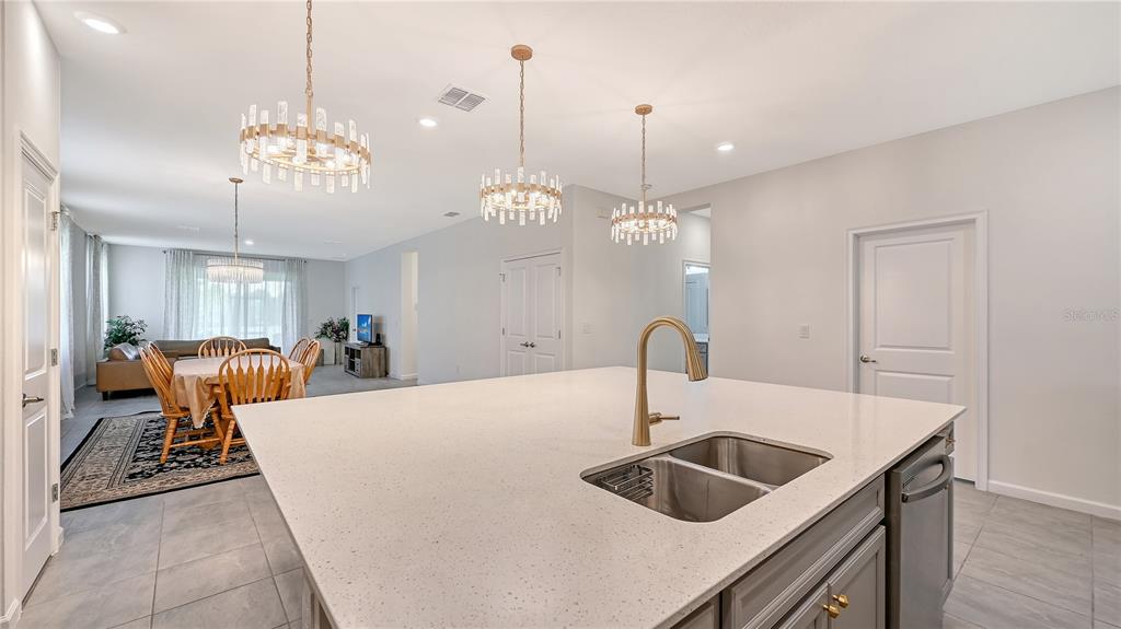 A kitchen island with a double sink sits in front of a dining area — 11710 LITTLE RIVER WAY, PARRISH, FL